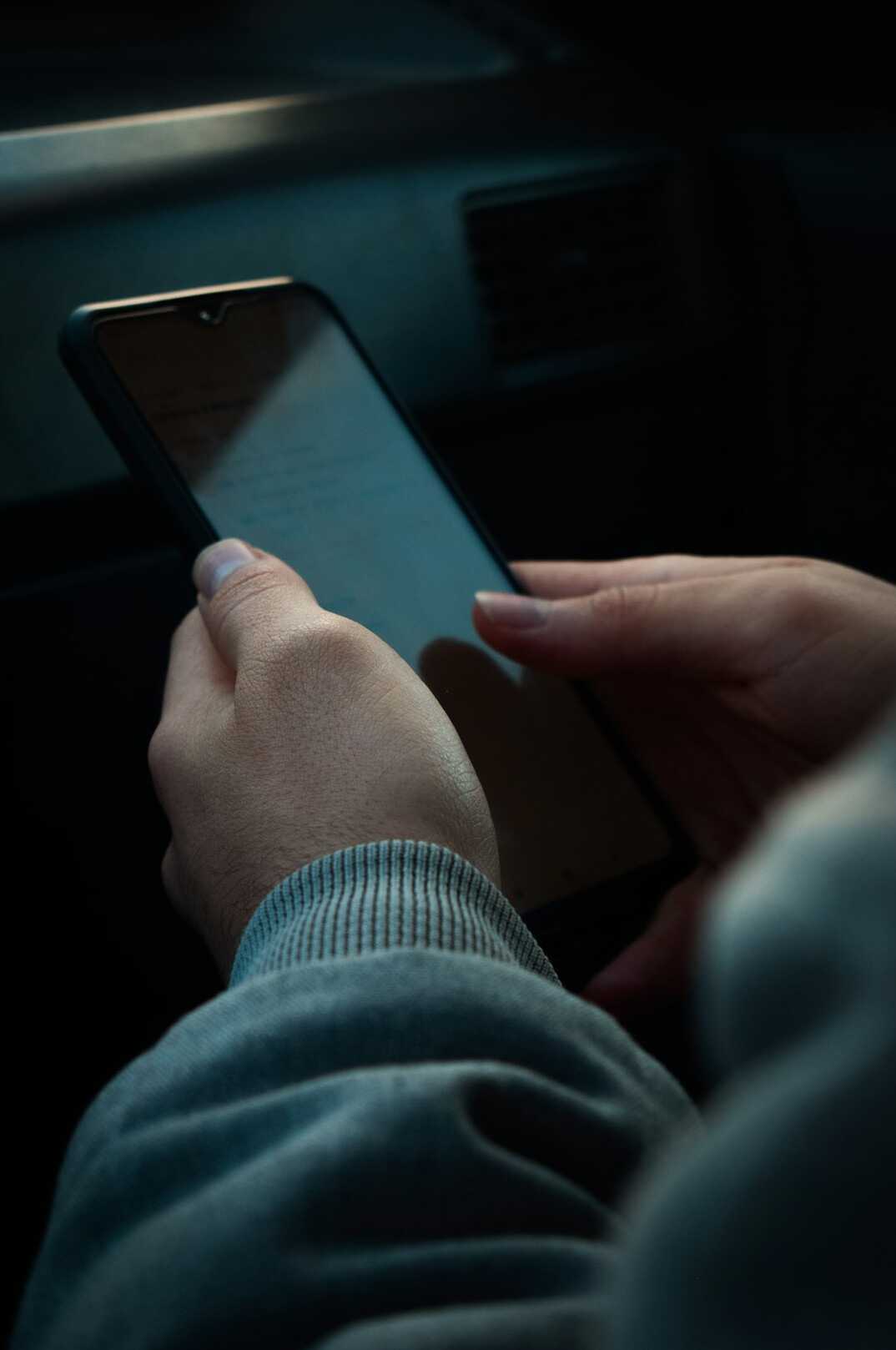 person scrolling phone at night